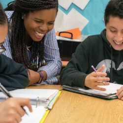 Teaching Fellow and Student laughing at table in the classroom of Knowles Teacher Initiative